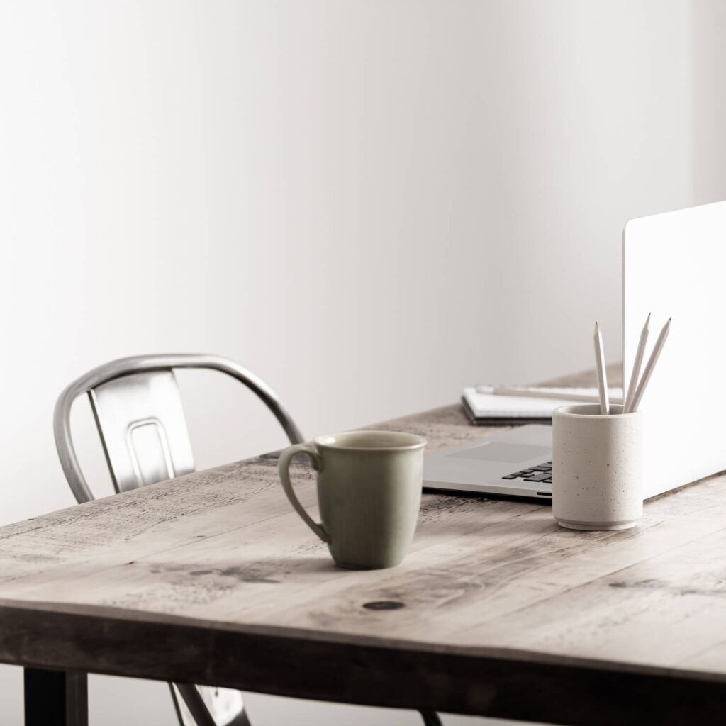 Table and chair with mug and laptop computer